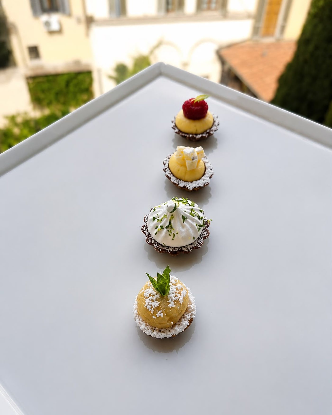 A row of miniature tartlets and petits fours